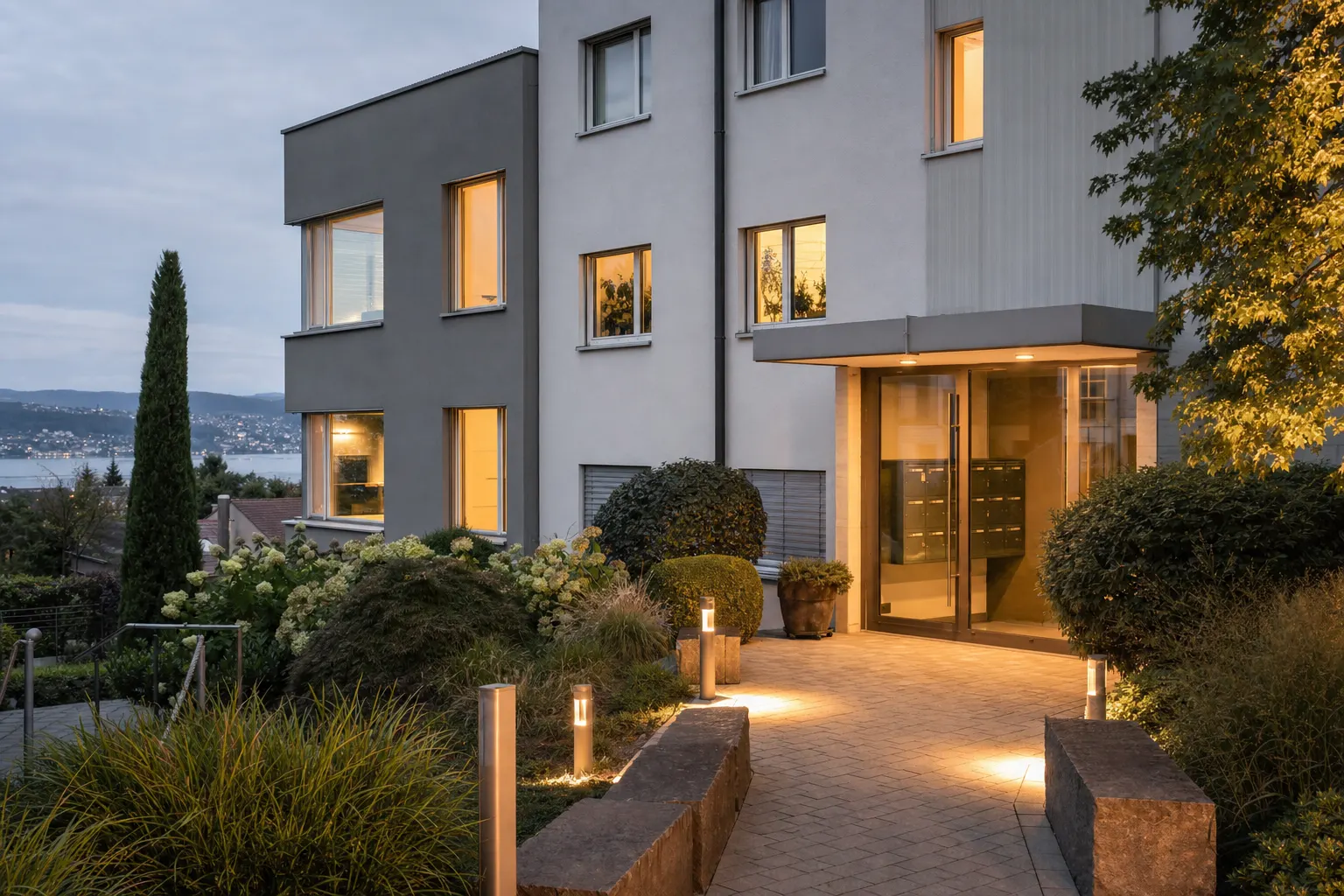 Wohnhaus mit beleuchteten Fenstern am Abend